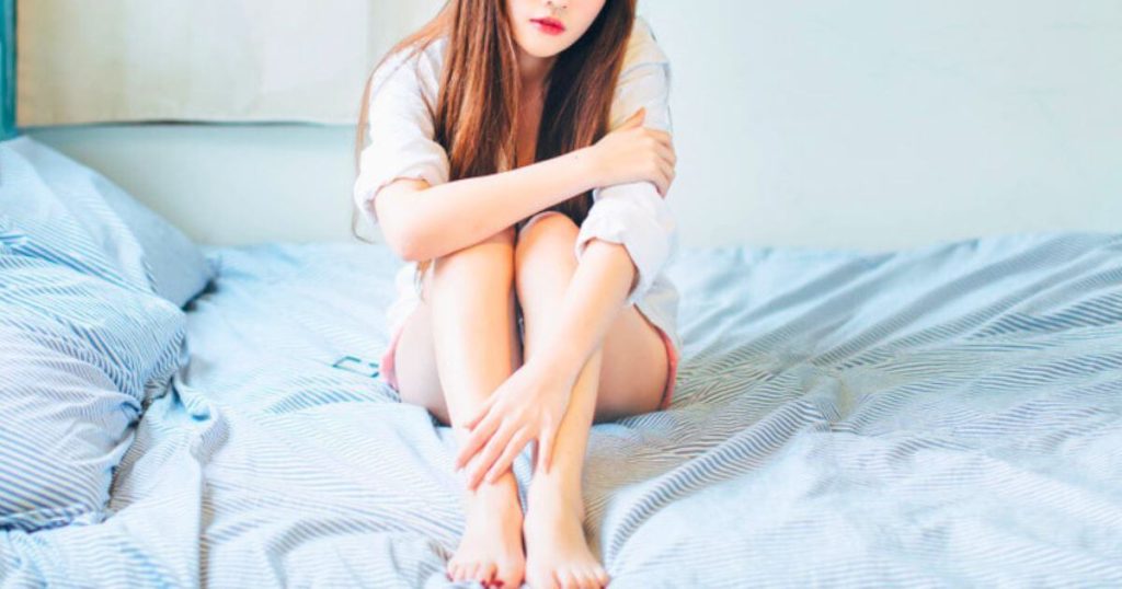ベッドに座る美人女性