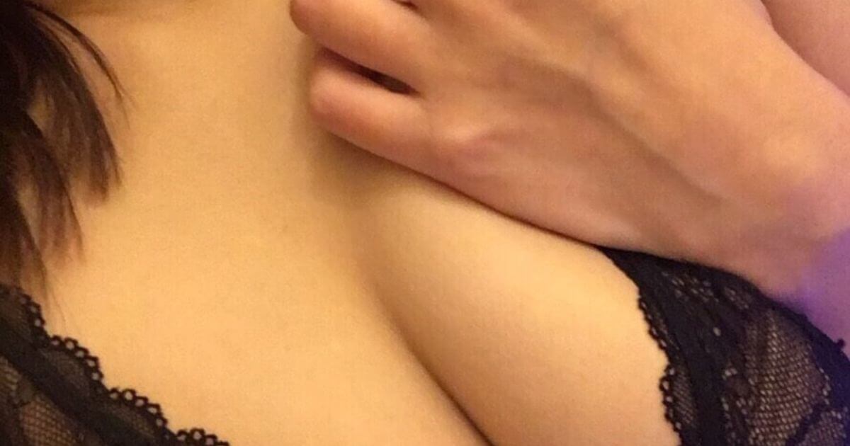胸に手を当てる黒いブラ姿の巨乳女性