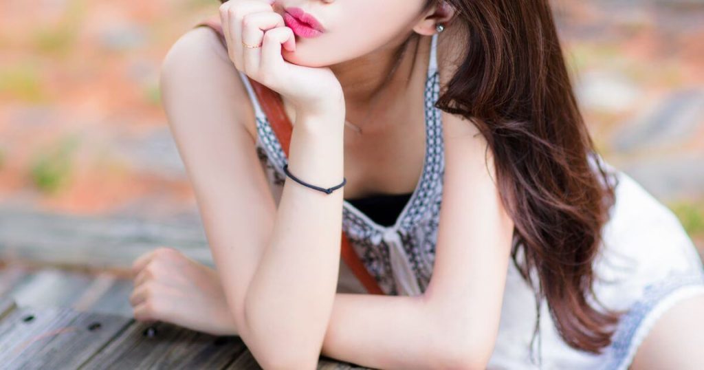 テーブルで頬杖をつく女性