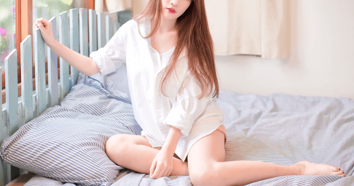 寝巻姿でベッドに座っている女性